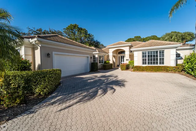 a front view of a house with a yard and potted plants
