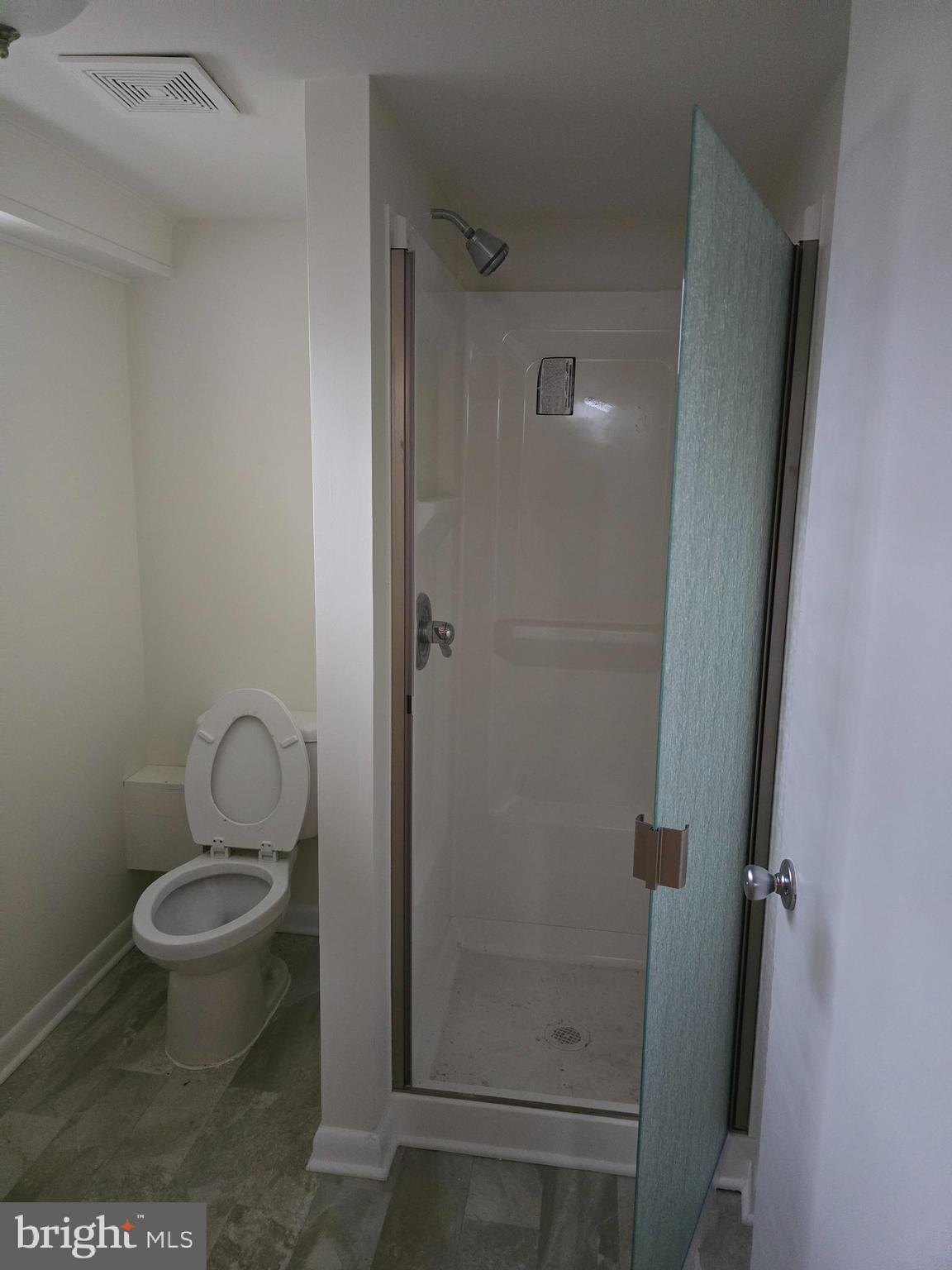 8305 Karl Avenue Rosedale, MD 21237 - Photo 11 of 13 a bathroom with a granite countertop toilet and a shower