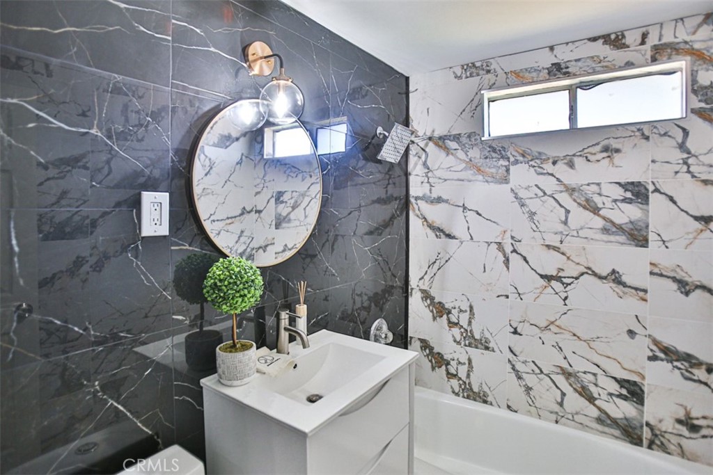 2540 West Picadilly Way Anaheim, CA 92801 - Photo 30 of 37 a bathroom with a sink a mirror and a shower