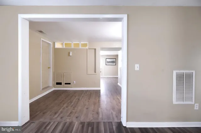 a view of a hallway with wooden floor and closet