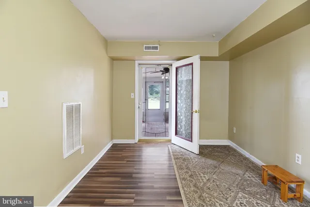 a view of a hallway with wooden floor and closet
