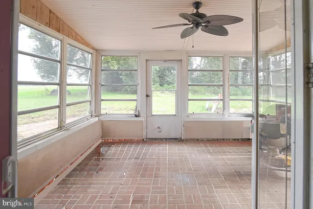 a view of an empty room and window ceiling fan