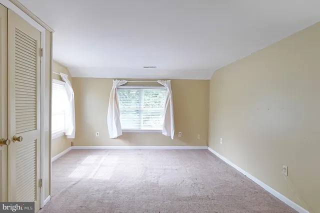 a view of a big room with windows and chandelier fan