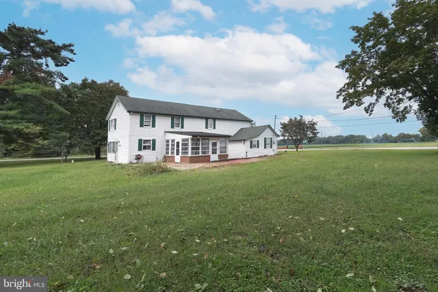 a view of a house with a big yard and large trees