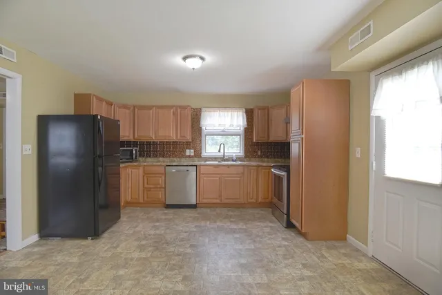 a kitchen with a refrigerator sink and cabinets