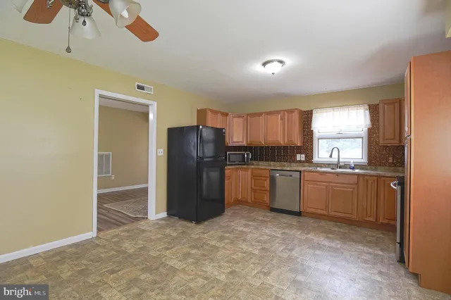 a kitchen with granite countertop a refrigerator and a sink