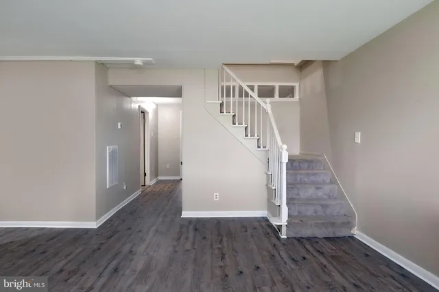 a view of a hallway with wooden floor and stairs
