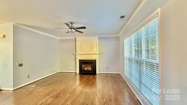 a view of empty room with a fireplace and wooden floor