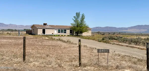 a view of a house with a yard and a large tree