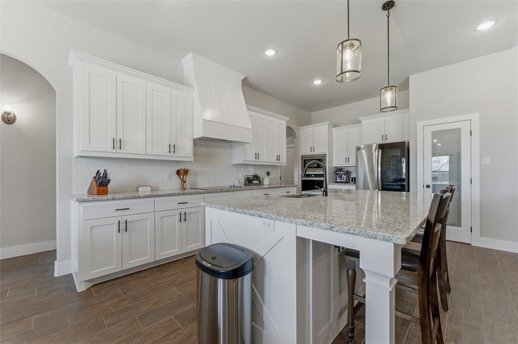 3020 Westfork Way Springtown, TX 76082 - Photo 15 of 40 a kitchen with kitchen island granite countertop a table chairs sink and cabinets