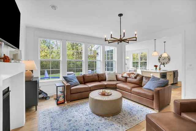 a kitchen with stainless steel appliances granite countertop a sink a stove a refrigerator and a wooden floors