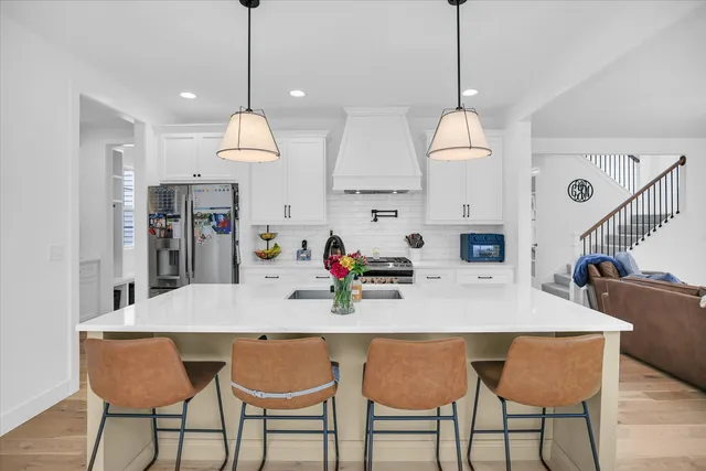 a kitchen with a sink a stove and a wooden floor