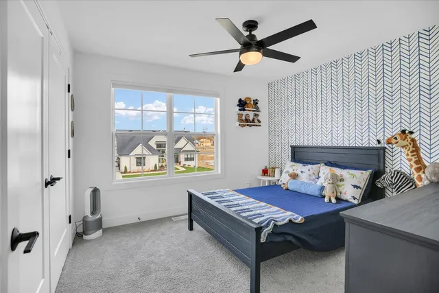 a bedroom with a white bed and a window