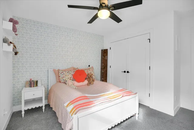 a spacious bedroom with a bed and a ceiling fan