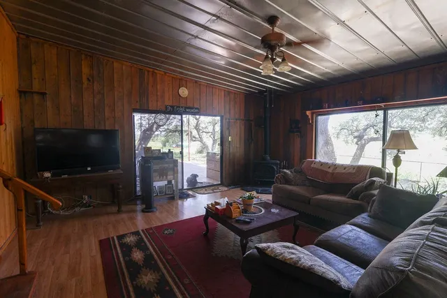 a living room with furniture a flat screen tv and a large window