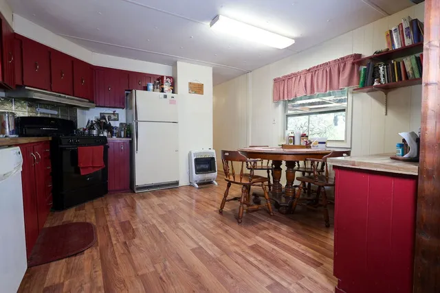 a kitchen with stainless steel appliances a dining table chairs and a refrigerator
