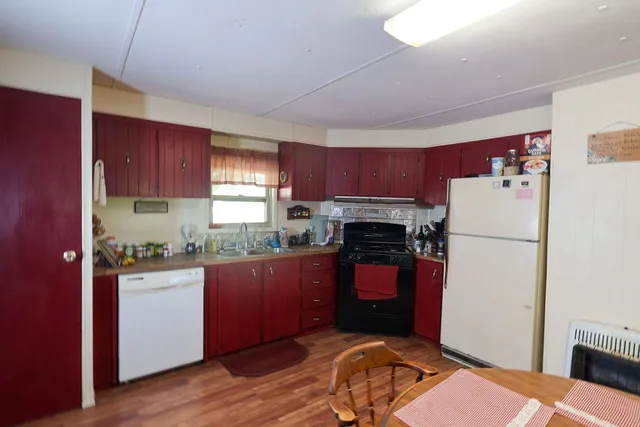 a kitchen with a refrigerator sink and wooden cabinets