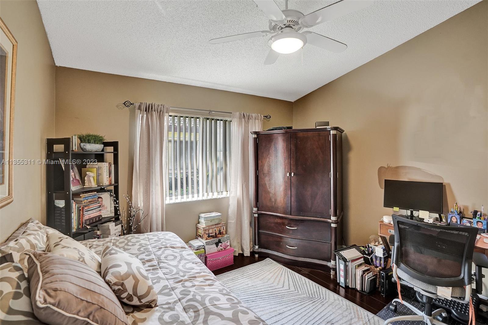 Tamarac Tamarac, FL 33321 - Photo 21 of 49 a bedroom with a bed and wooden floor