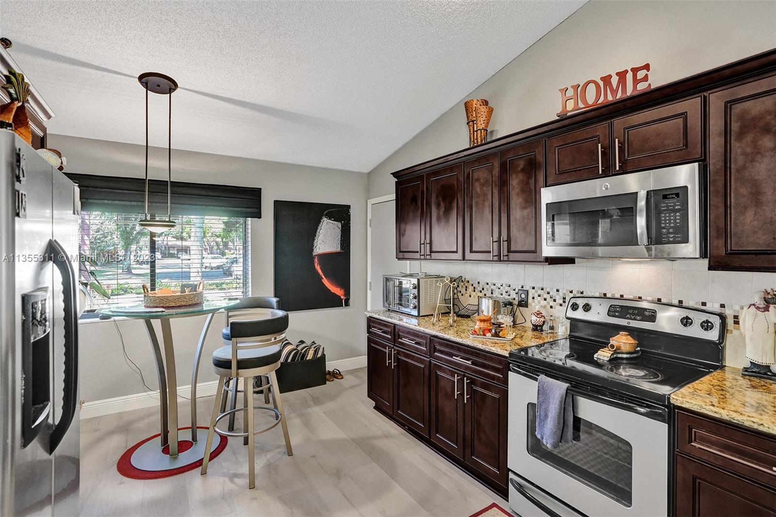 Tamarac Tamarac, FL 33321 - Photo 27 of 49 a kitchen with stainless steel appliances granite countertop a stove top oven a sink a dining table and chairs