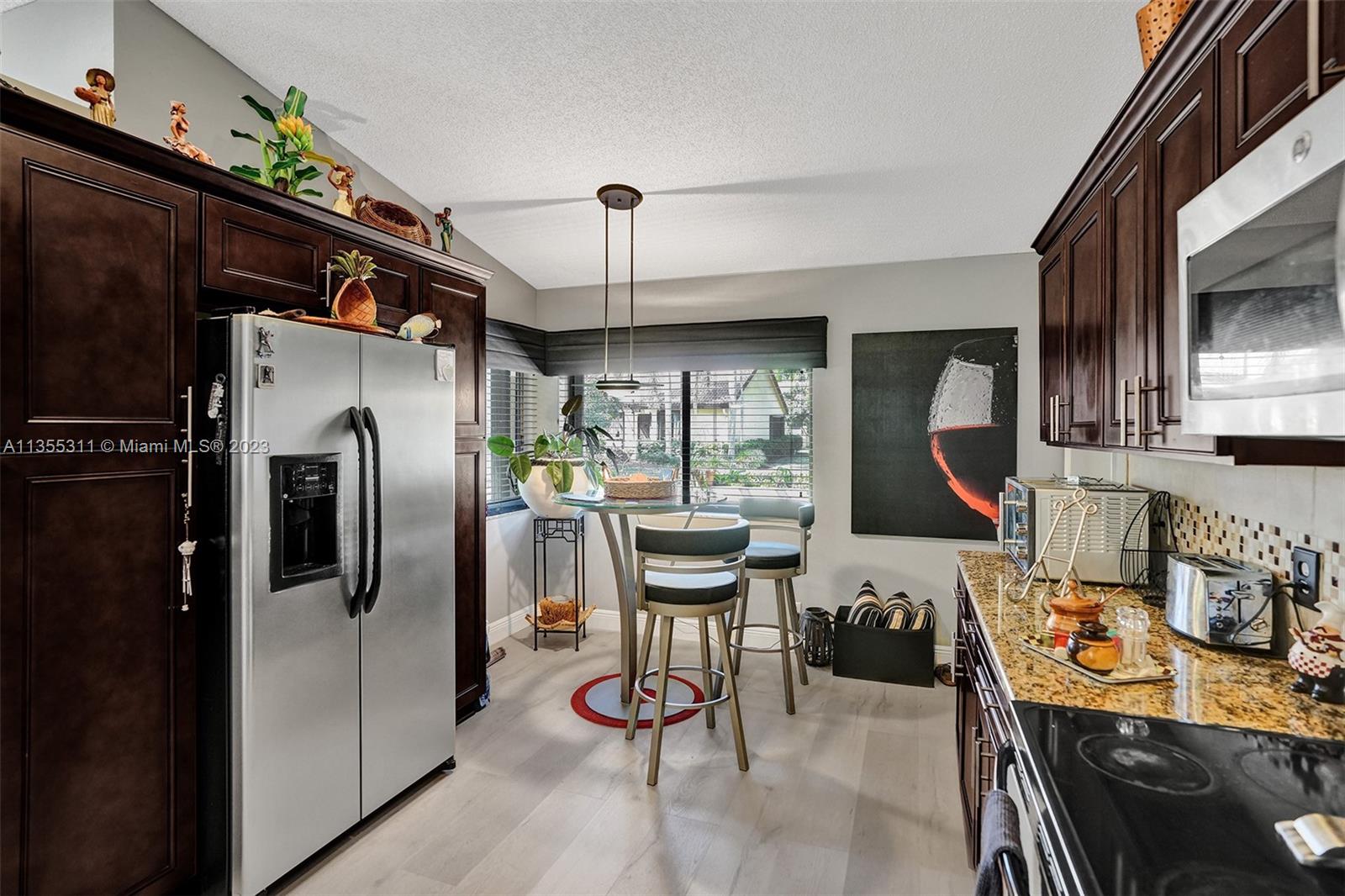 Tamarac Tamarac, FL 33321 - Photo 30 of 49 a kitchen with stainless steel appliances kitchen island granite countertop a refrigerator and a stove top oven