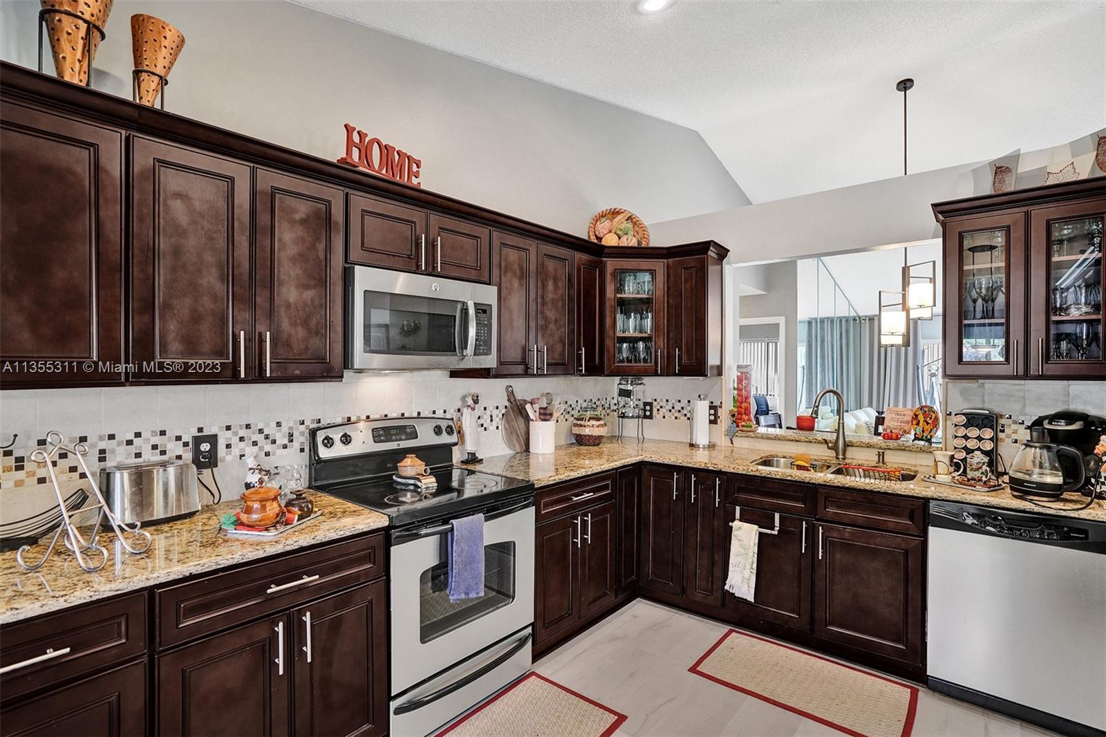 Tamarac Tamarac, FL 33321 - Photo 33 of 49 a kitchen with a sink a stove and cabinets