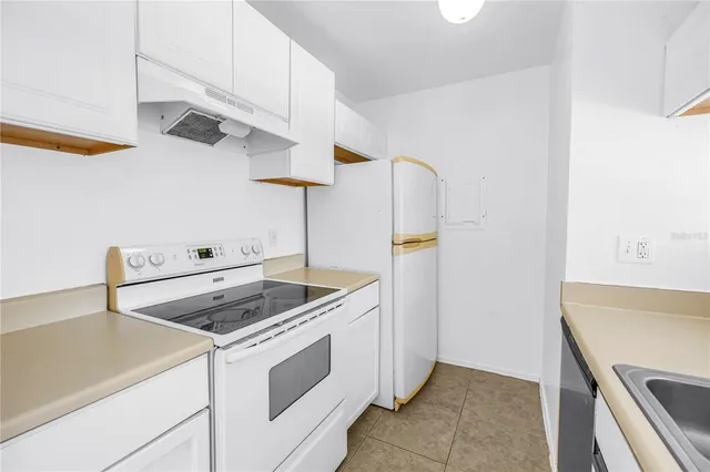 a kitchen with a sink a stove and cabinets