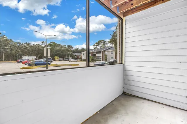 a view of a porch with wooden floor and a door