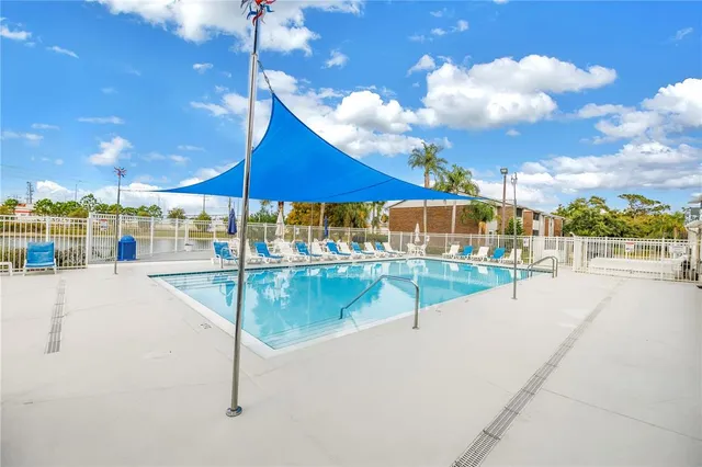 a swimming pool with outdoor seating and yard in the back