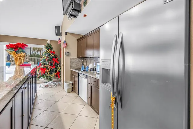 a kitchen with stainless steel appliances granite countertop a sink a stove and a refrigerator
