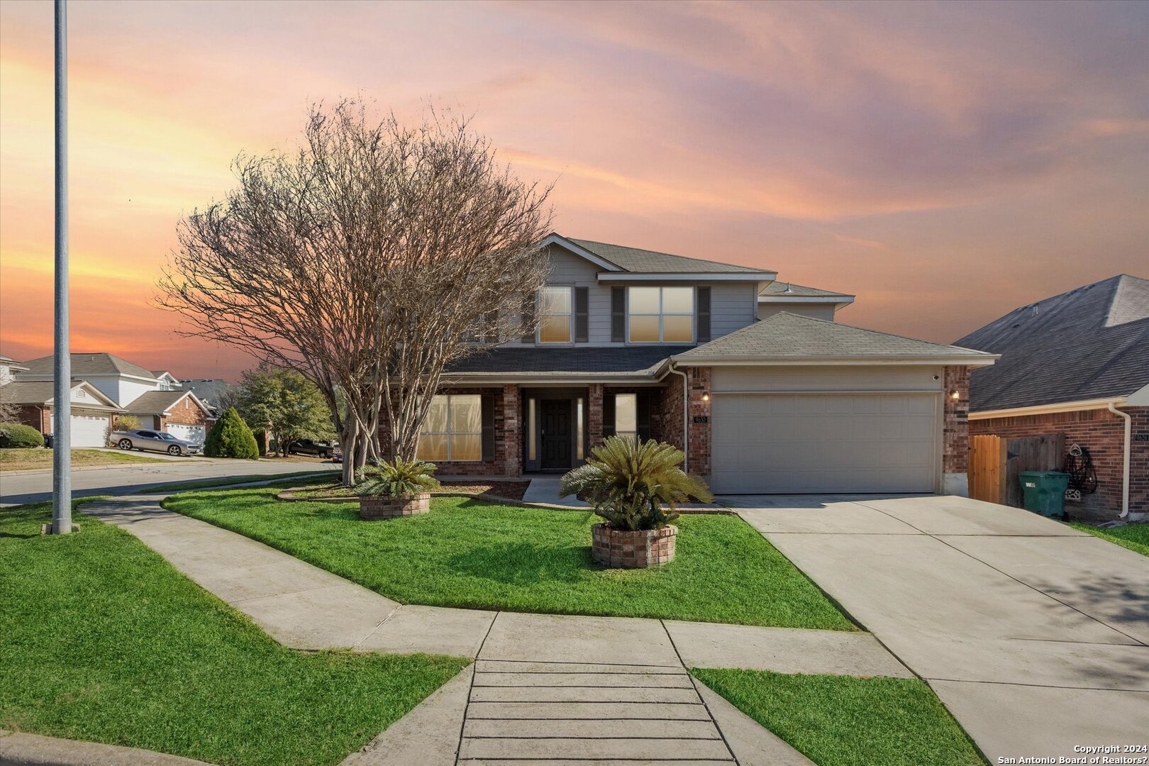 a front view of a house with a yard and trees