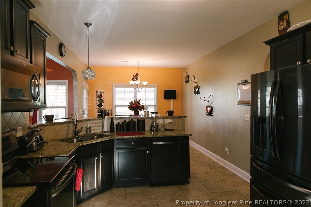 153 Shellbark Drive Spring Lake, NC 28390 - Photo 13 of 48 a kitchen with sink refrigerator and cabinets
