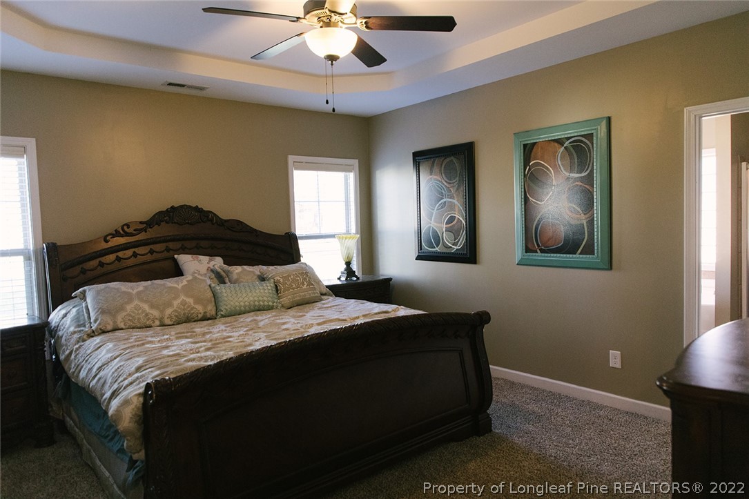 153 Shellbark Drive Spring Lake, NC 28390 - Photo 22 of 48 a bedroom with a large bed and a chandelier