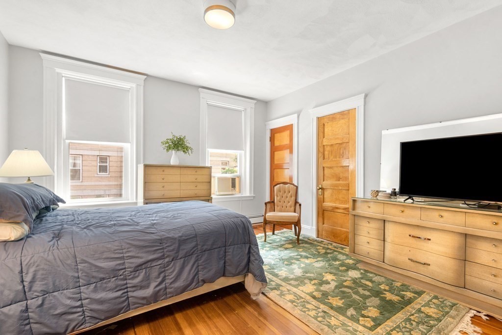 815 Centre Street, Unit 1 Boston, MA 02130 - Photo 12 of 30 a bedroom with a bed and flat screen tv