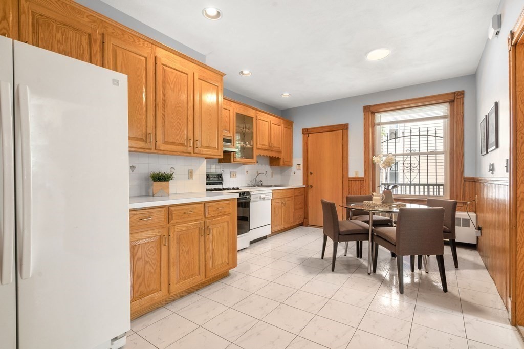 815 Centre Street, Unit 1 Boston, MA 02130 - Photo 16 of 30 a kitchen with granite countertop cabinets a dining table and chairs
