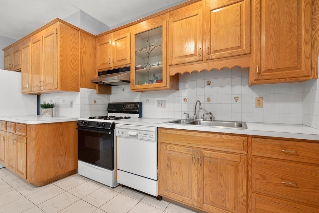 815 Centre Street, Unit 1 Boston, MA 02130 - Photo 18 of 30 a kitchen with stainless steel appliances granite countertop a sink a stove and white cabinets