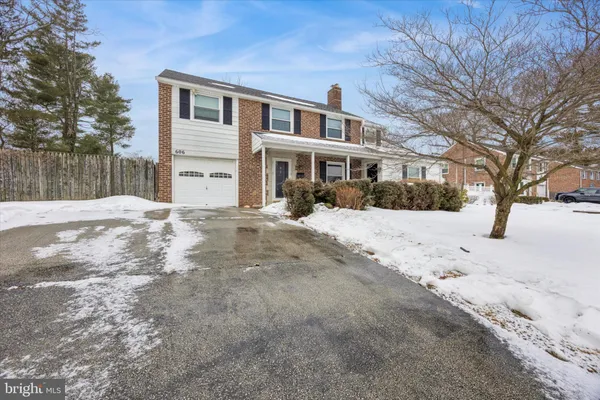 a front view of a house with a yard covered in snow