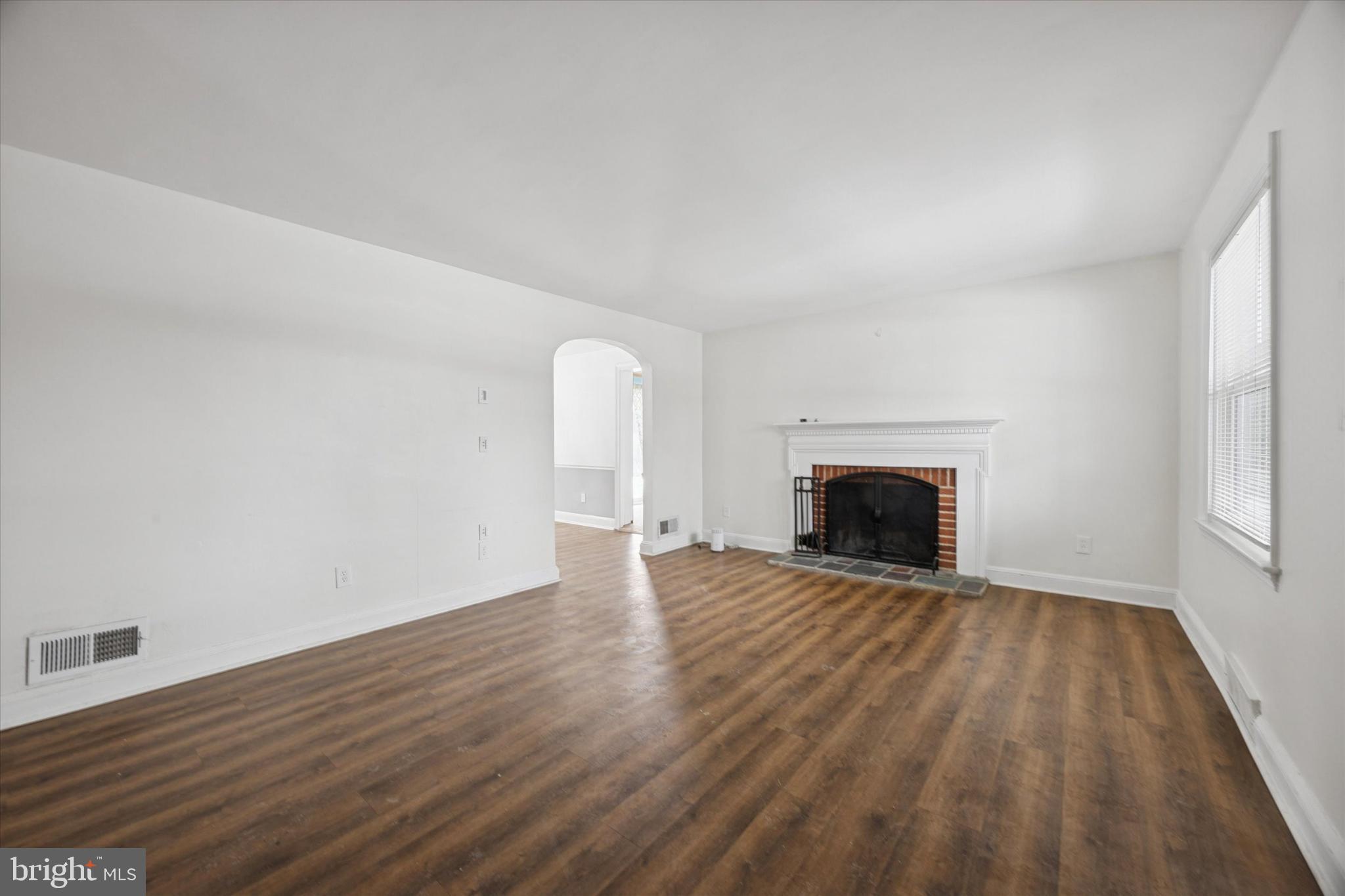 606 West Springfield Road Springfield, PA 19064 - Photo 2 of 25 a view of empty room with wooden floor and fireplace
