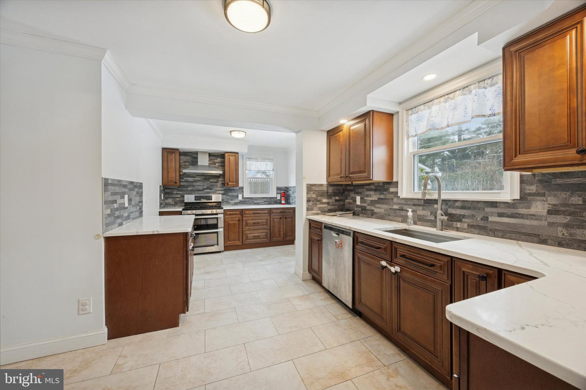 606 West Springfield Road Springfield, PA 19064 - Photo 6 of 25 a large kitchen with stainless steel appliances granite countertop a sink counter space cabinets and a large window