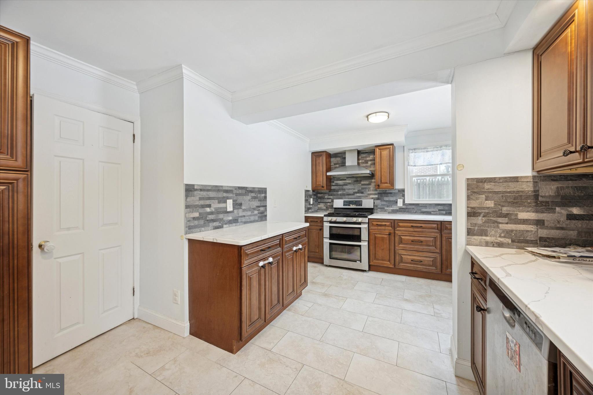 606 West Springfield Road Springfield, PA 19064 - Photo 7 of 25 a kitchen with stainless steel appliances granite countertop a stove top oven a sink and a refrigerator