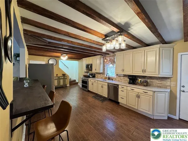 a kitchen with stove a sink and chairs