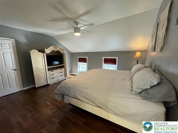 a spacious bedroom with a bed and a flat screen tv