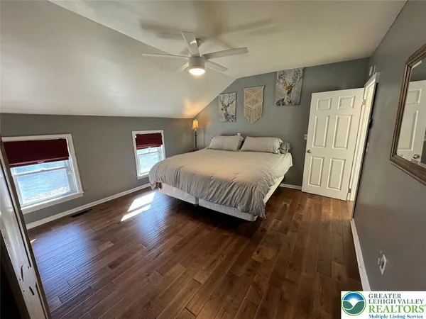 a spacious bedroom with a bed and a wooden floor