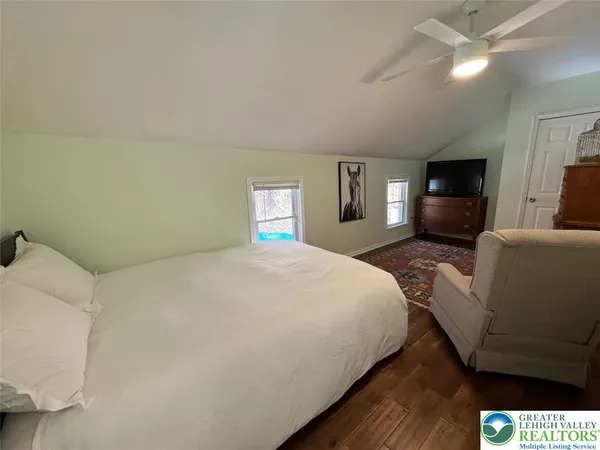 a spacious bedroom with a bed and a flat screen tv
