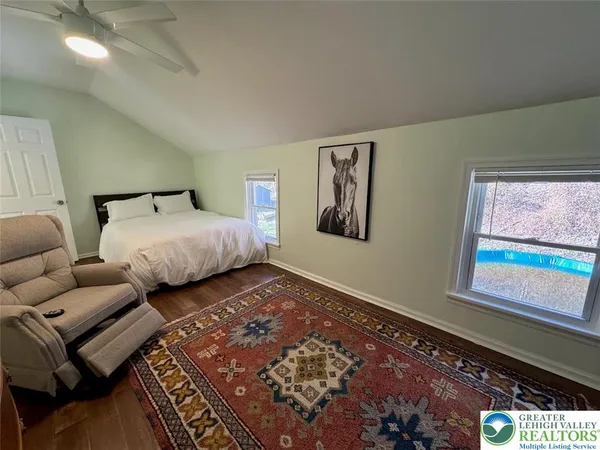 a bedroom with bed couch and window