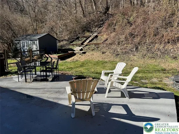 a view of a patio with dining table and chairs with wooden floor and fence