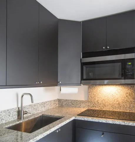 a kitchen with granite countertop a sink and a stove next to a window