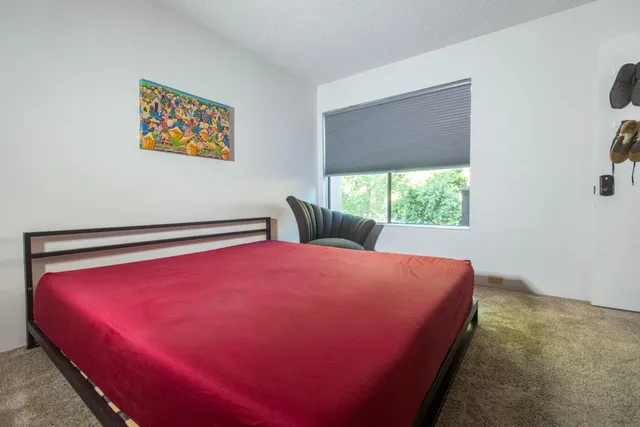 a bed sitting in a bedroom next to a window