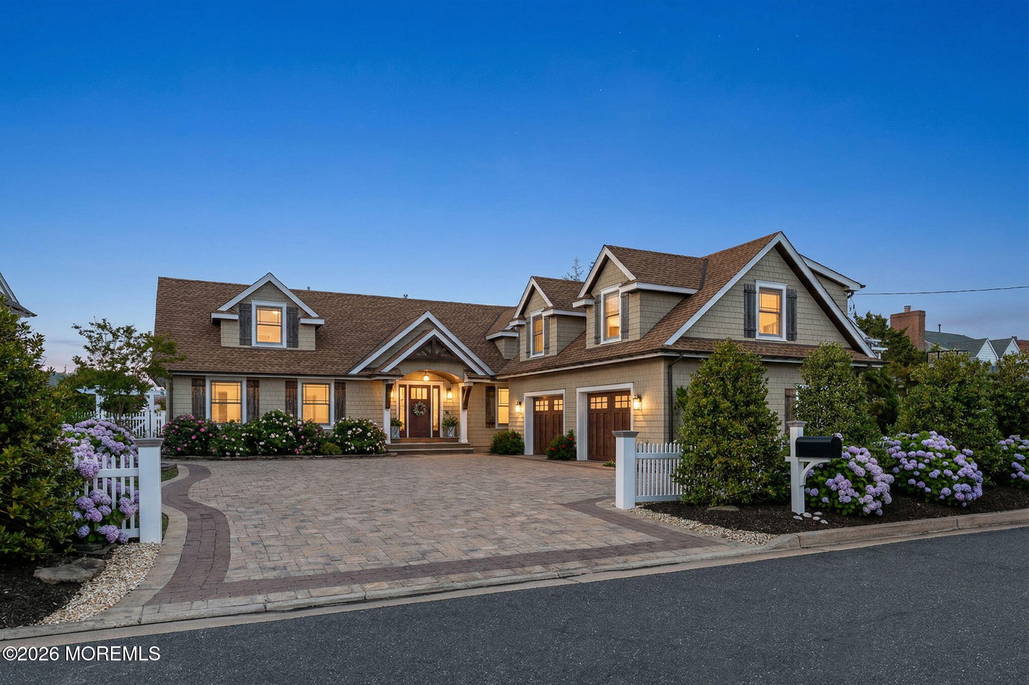 a front view of a house with a yard and potted plants