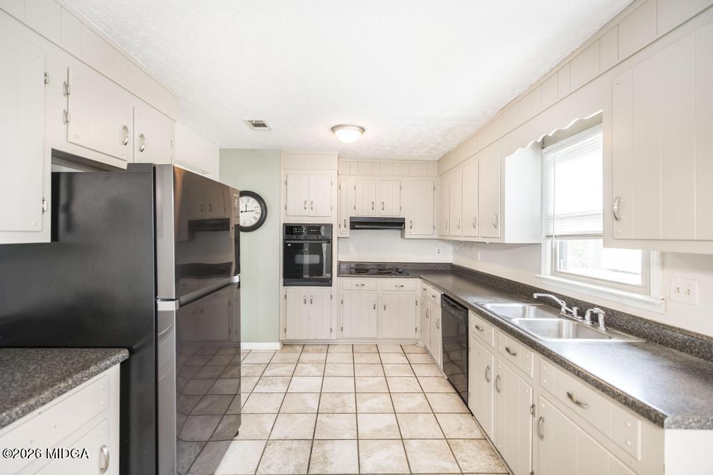 112 Prairie Boulevard Centerville, GA 31028 - Photo 13 of 32 a kitchen with granite countertop a refrigerator sink and cabinets