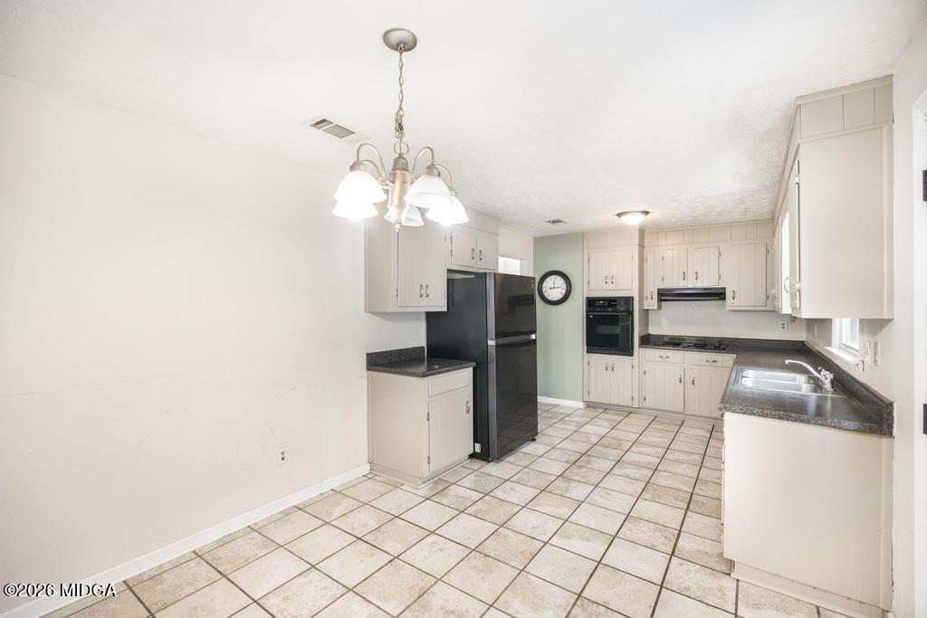 112 Prairie Boulevard Centerville, GA 31028 - Photo 15 of 32 a kitchen with stainless steel appliances kitchen island granite countertop a refrigerator a stove and a sink